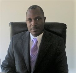 Photo of Dr. John Kwagyan sitting in an office chair
